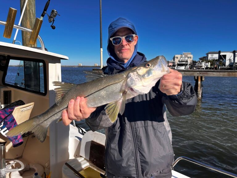a man holding a beautiful snook caught on Captain Rich's 24 foot Parker in Fort Myers, FL