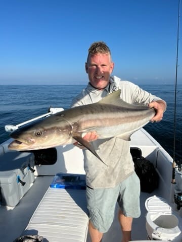 Captain Rich holding a cobia on his 27 foot skiff